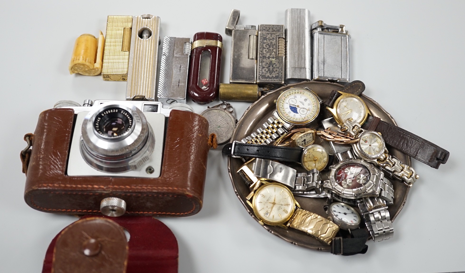 A collection of mixed wristwatches and cigarette lighters and a camera